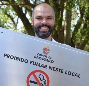 O alcaide tucano Bruno Covas com placa proibindo fumar nas praças e parques de São Paulo